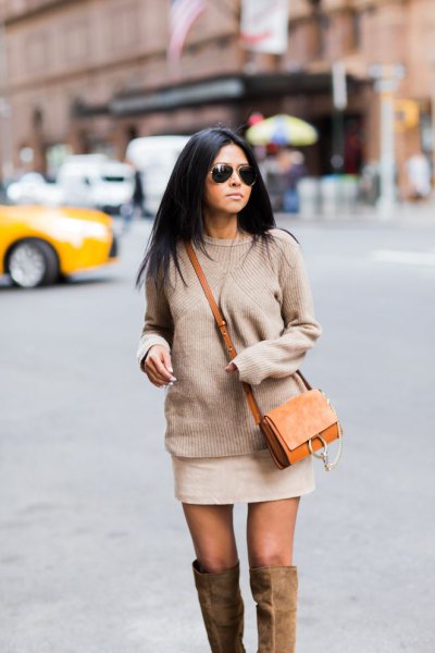 Blush pink chunky knit sweater with mini ivory skirt and brown suede bag