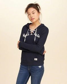Graphic hoodie with a black lace-up neckline and dark blue skinny jeans