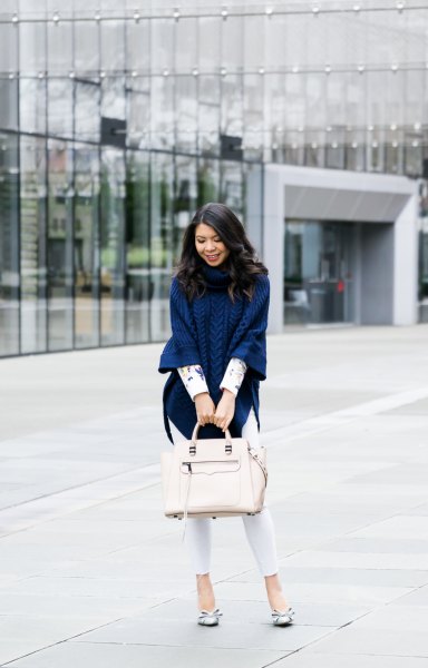 Navy cable knit poncho sweater with white skinny jeans