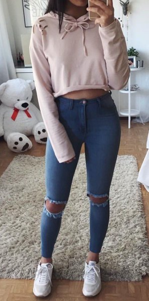 Light pink cropped pullover hoodie with ripped skinny jeans