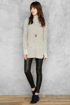 gray tunic sweater with stand-up collar and black leather leggings