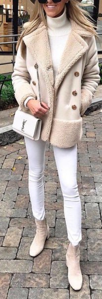 Light pink coat with fleece collar, white jeans and light gray ankle boots with side zip