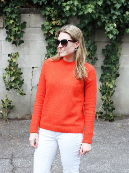 Orange chunky cotton sweater with white skinny jeans