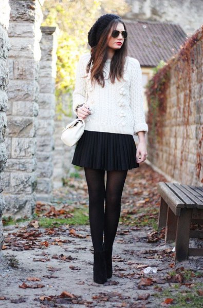 white cable knit sweater with black pleated mini skirt
