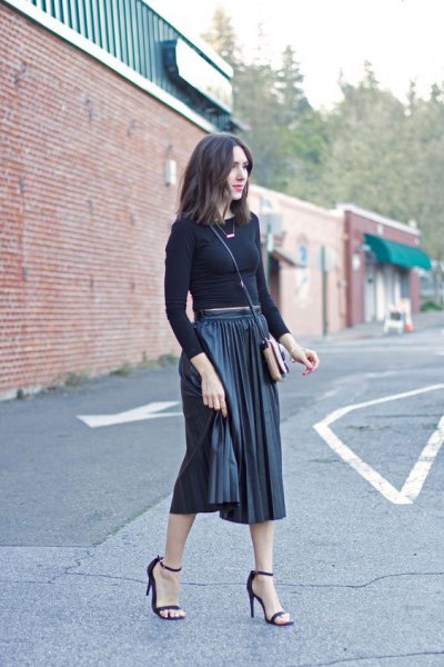 Figure-hugging, cropped knit sweater with a black pleated skirt