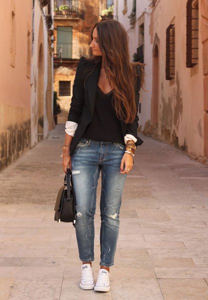 black blazer with plunging V-neck blouse and blue ripped jeans