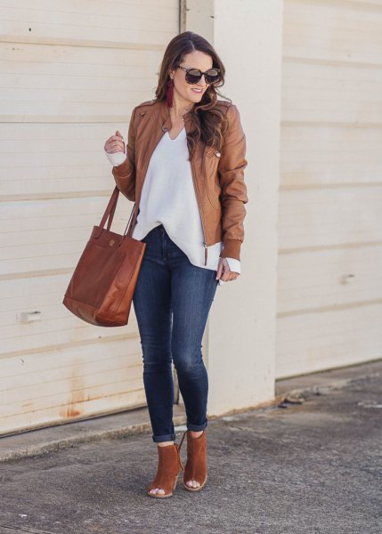 Leather jacket with white V-neck blouse and open camel boots