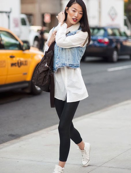 white tunic shirt with buttons, denim vest and black short leggings