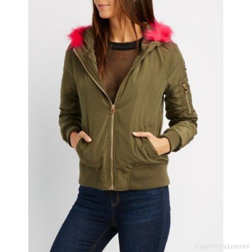 green bomber jacket with mesh blouse and blue jeans