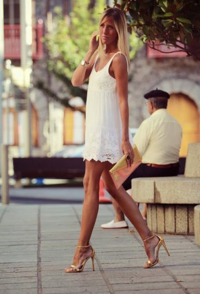 white mini dress with scalloped hem and gold open toe heels