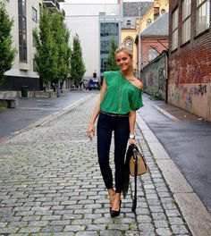 Bright emerald green one shoulder top and black skinny jeans