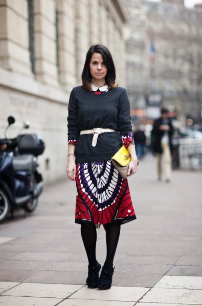 black sweater and red and white printed skirt