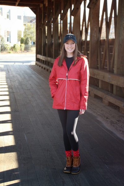 red rain jacket with black leggings and lace-up ankle boots