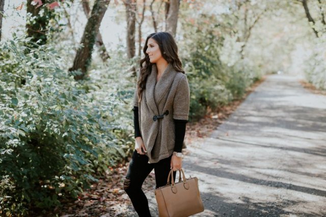 gray half sleeve sweater with black long sleeve shirt and brown leather bag