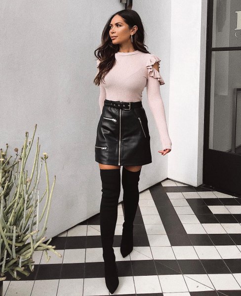 Light pink cold shoulder style sweater and black leather zippered mini skirt