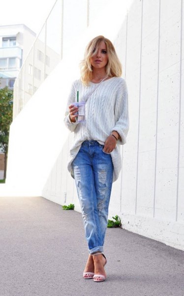 white grainy knit sweater with blue ripped cuffed jeans