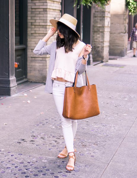 Straw hat with a cashmere cardigan over the shoulder and a crop top