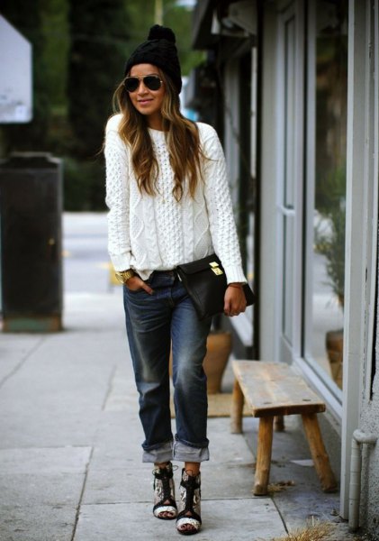 white chunky knit sweater with black cuffed boyfriend jeans and knit hat