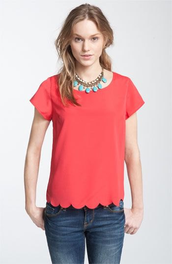 red scalloped short-sleeved shirt with blue skinny jeans