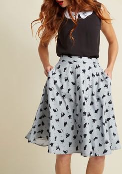 black sleeveless top with white printed flared chiffon midi skirt with pockets