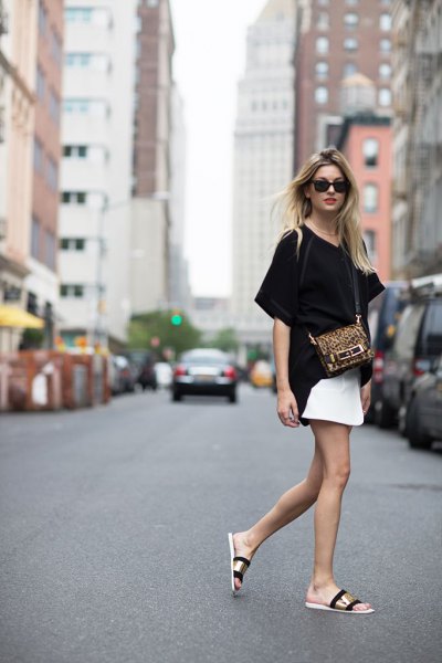 black oversized t-shirt with white mini skirt and black and gold summer sandals