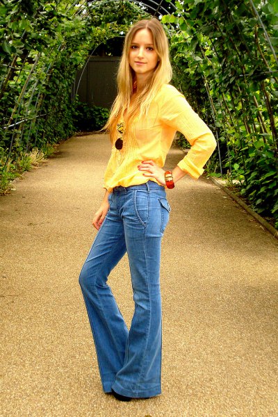 bright yellow long sleeve blouse with blue flared jeans
