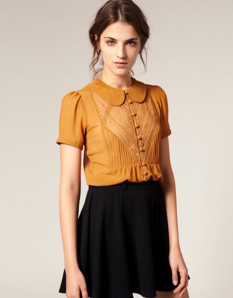 gold short-sleeved blouse with round collar and buttons and black mini skirt