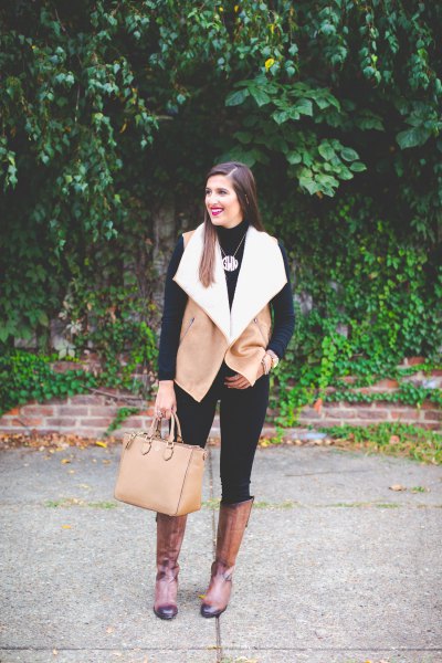 Camel and white shearling vest with black skinny jeans and knee high boots