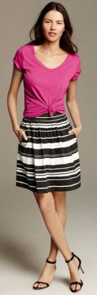 pink knotted scoop neck t-shirt and black and white striped knee length skirt