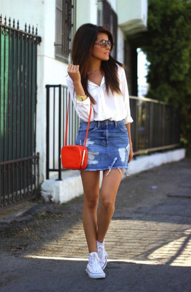 white button down shirt, a blue ripped mini skirt and a small brown shoulder bag