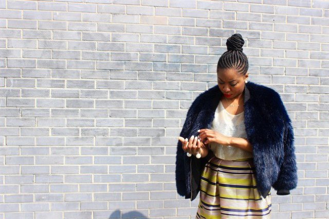 dark faux fur bomber jacket with a yellow and blue high waist midi skirt