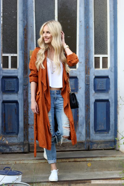 red longline trench coat with ripped boyfriend jeans and white sneakers