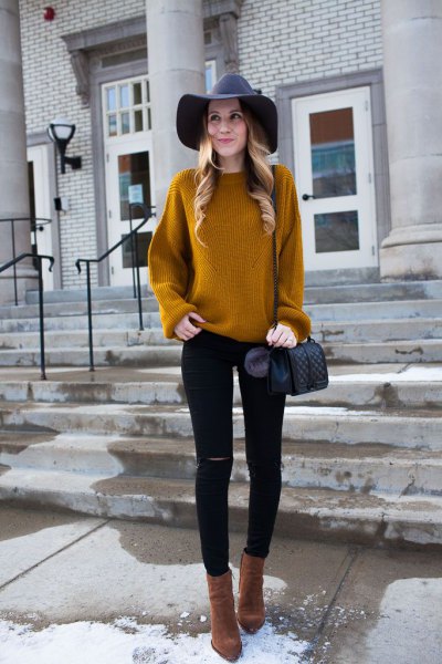 yellowish-brown ribbed sweater with black floppy hat