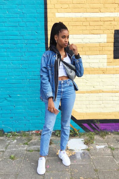 blue denim jacket with a white, short vest top and high-rise jeans