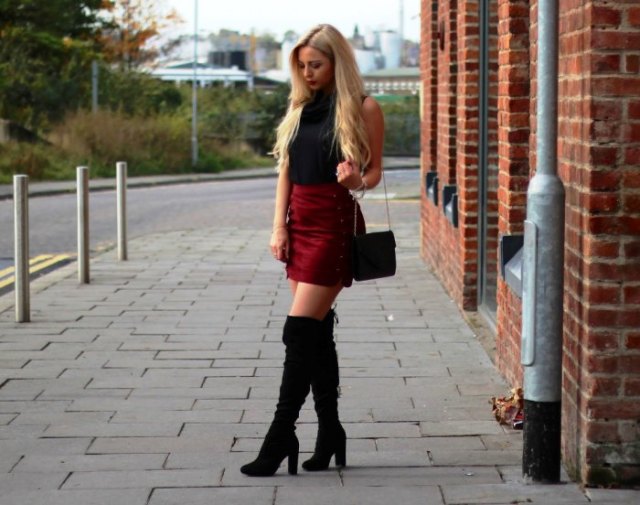 Black turtleneck sleeveless top, burgundy miniskirt and tall boots
