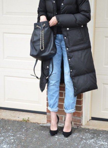 black mid-length puffer coat with cuffed blue jeans