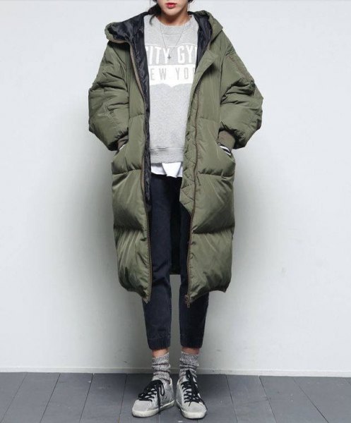 green long puffer coat with gray sweatshirt and black jeans