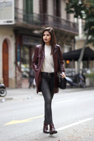 long maroon leather jacket with white sweater and gray jeans