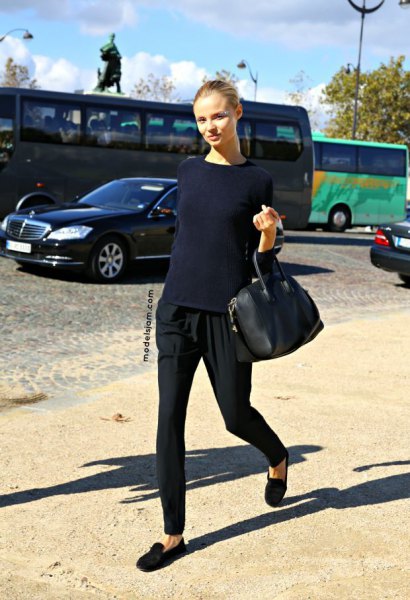 Dark blue fitted sweater with black tapered leg trousers and black suede shoes