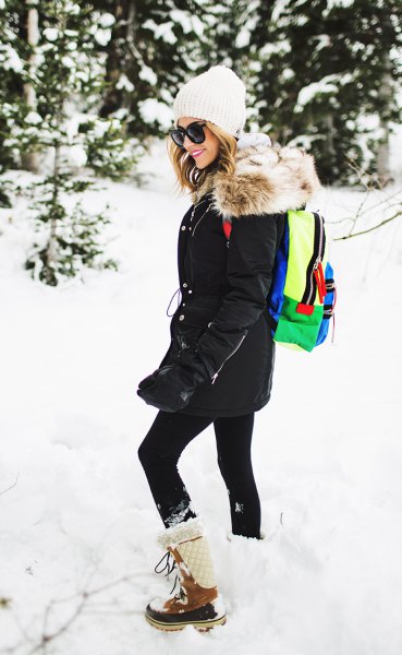 black coat with leggings and white and brown mid-calf snow boots