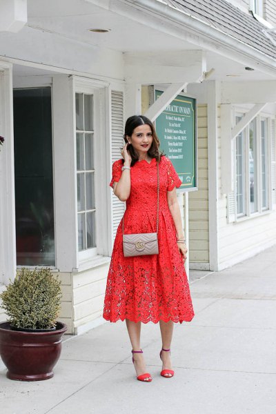 Orange short sleeve lace midi dress with a blush pink small purse