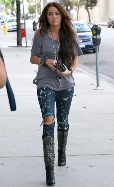 Ripped paint skinny jeans and black leather knee high boots