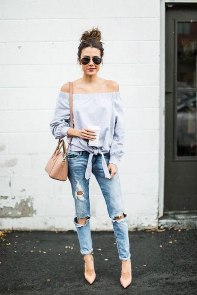 Light blue knotted off the shoulder blouse with really ripped jeans with cuffs