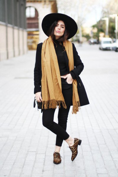 black longline blazer with an orange fringed scarf and leopard print slippers