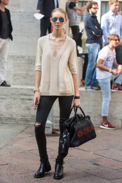 Light pink sweater with a deep V-neck, black jeans and short boots