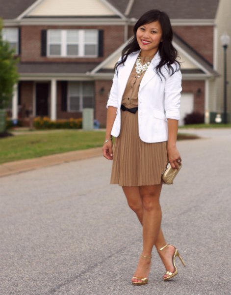 white blazer with a blush pink pleated mini skirt and gold heels