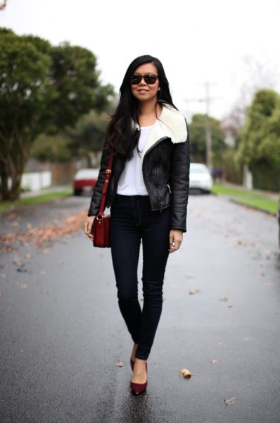 black flight jacket with white fur collar and skinny jeans