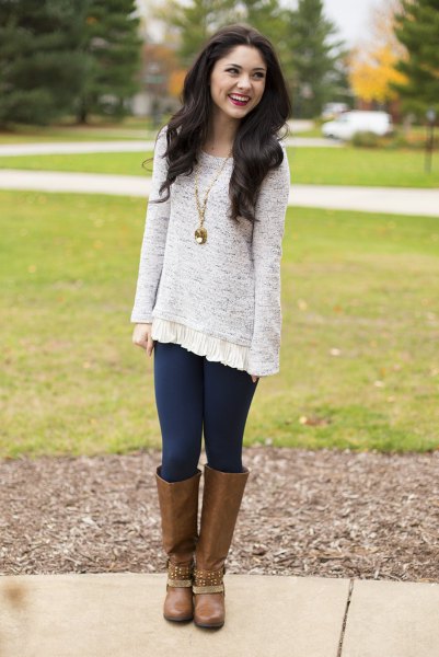 mottled gray tunic sweater with dark blue leggings and brown knee-high boots