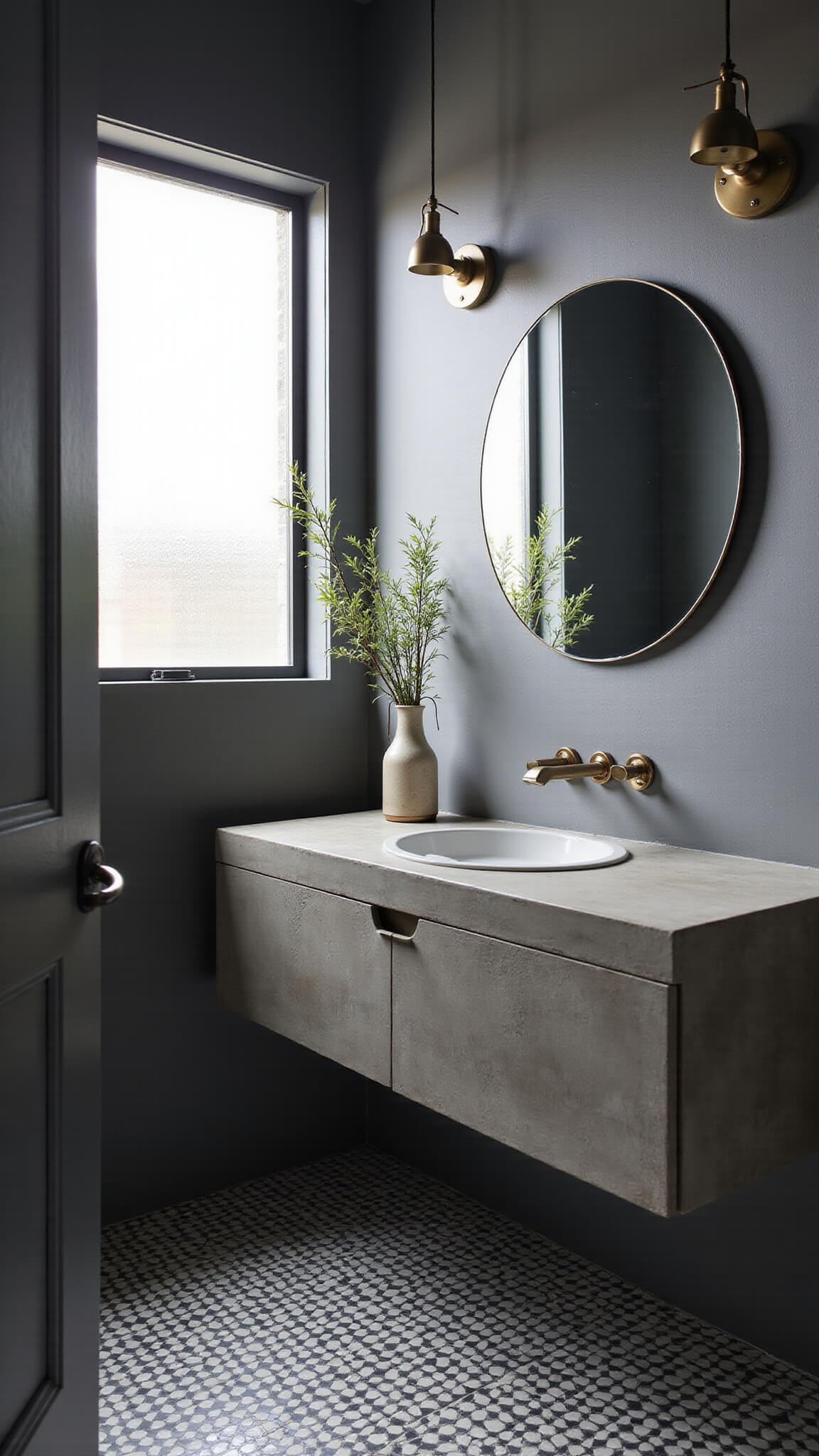 Contemporary urban bathroom featuring a floating concrete vanity, matte charcoal tiles, geometric black and white flooring, and soft morning light through frosted glass.