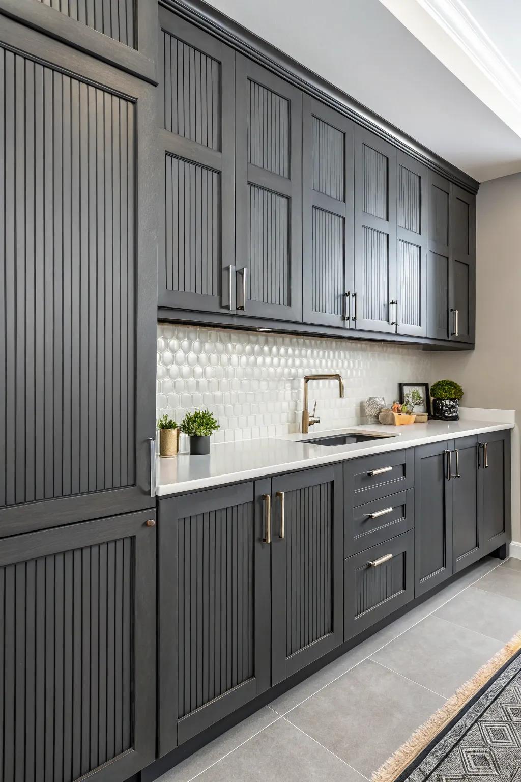 Vertical grooved panels adding height and texture to dark gray cabinets.